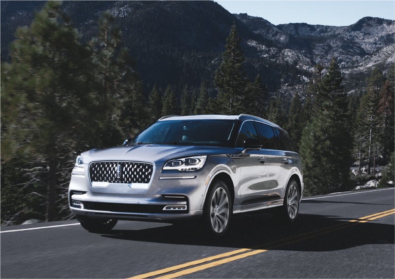 A 2023 Lincoln Aviator® Grand Touring SUV being driven on a winding road to demonstrate the capabilities of all-wheel drive | Lincoln of Ramsey in Ramsey NJ