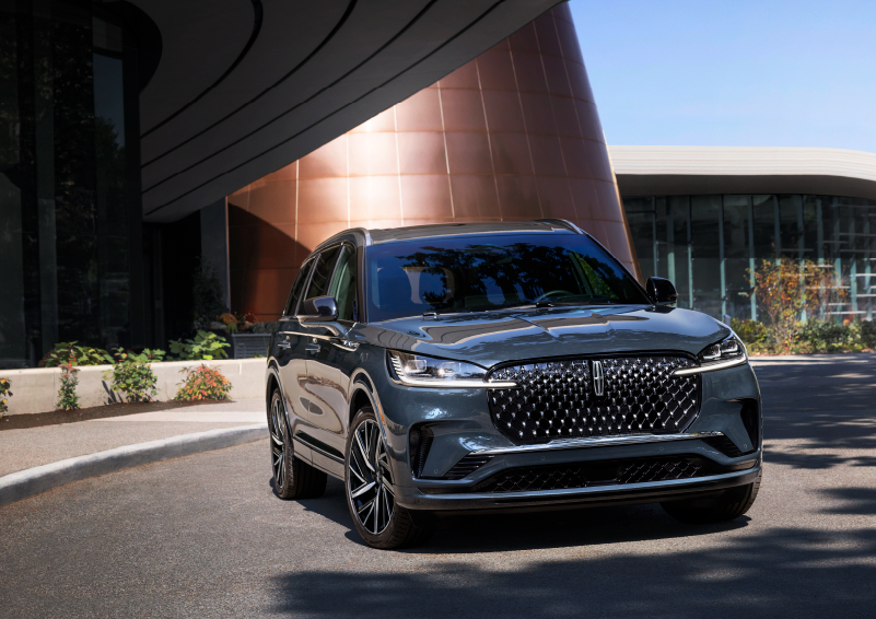 A gray 2025 Lincoln Aviator® SUV is parked outside a modern building with the sun shining. | Lincoln of Ramsey in Ramsey NJ