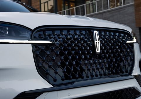 The black grille of a white 2025 Lincoln Aviator® SUV is shown with its fog lights on. | Lincoln of Ramsey in Ramsey NJ