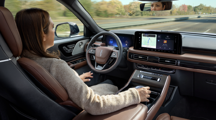 A woman is seen sitting in the driver’s seat of her 2025 Lincoln Aviator® SUV with her hands off the steering wheel. | Lincoln of Ramsey in Ramsey NJ