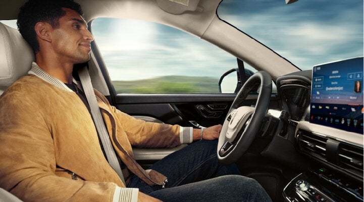 A person is shown using Lincoln BlueCruise hands-free highway driving technology on a divided highway called a Hands-Free Blue Zone. | Lincoln of Ramsey in Ramsey NJ