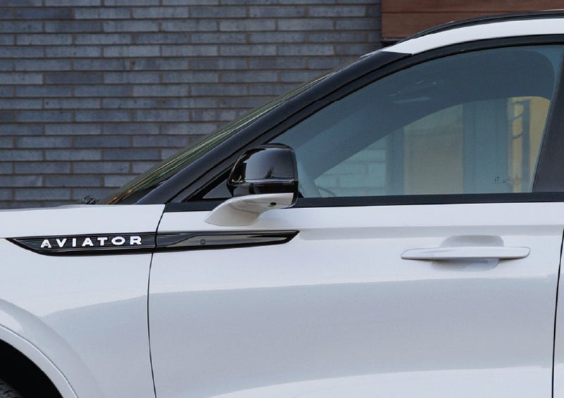 The driver’s side door and fender badging of a white 2026 Lincoln Aviator® SUV are showcased. | Lincoln of Ramsey in Ramsey NJ