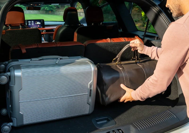 A man loads luggage into the rear of a 2026 Lincoln Aviator® SUV through the opened rear liftgate. | Lincoln of Ramsey in Ramsey NJ