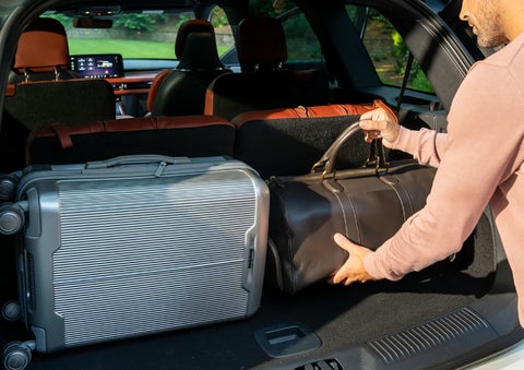 A man loads luggage into the rear of a 2026 Lincoln Aviator® SUV through the opened rear liftgate. | Lincoln of Ramsey in Ramsey NJ
