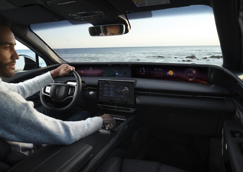 A driver of a parked 2026 Lincoln Nautilus® SUV takes a relaxing moment at a seaside overlook while inside his Nautilus. | Lincoln of Ramsey in Ramsey NJ