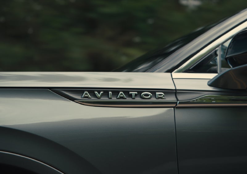 The driver’s side door and fender badging of a gray 2027 Lincoln Aviator® SUV are showcased. | Lincoln of Ramsey in Ramsey NJ