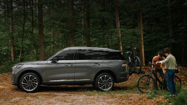 A father and son load e-bikes on a bike rack attached to a 2027 Lincoln Aviator® SUV. | Lincoln of Ramsey in Ramsey NJ