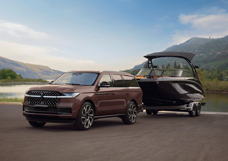 A 2027 Lincoln Navigator® SUV tows a large boat.