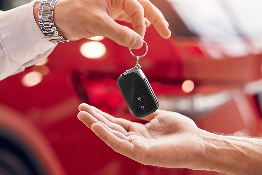 Close-up of a person's hand handing over car keys to another